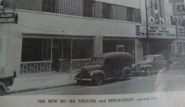 Black-and-white 1949 photograph of the newly built Ro-Na Theatre on Third Street, with 1940s cars parked outside and the original marquee announcing the grand opening